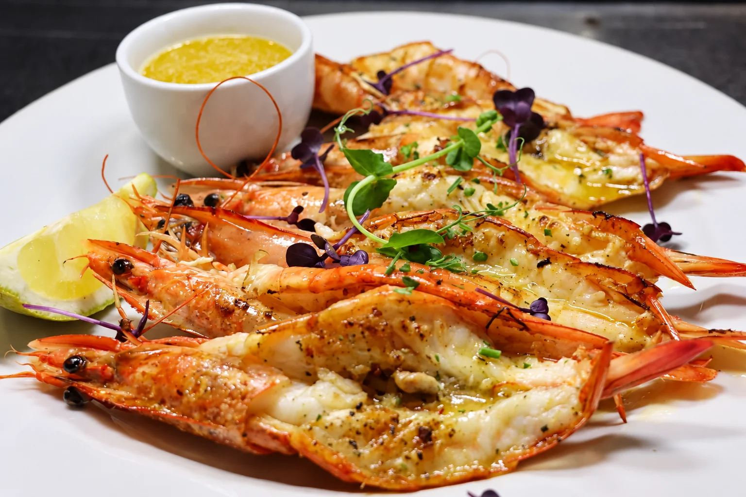 Grilled prawns with lemon butter, herbs and a lemon wedge