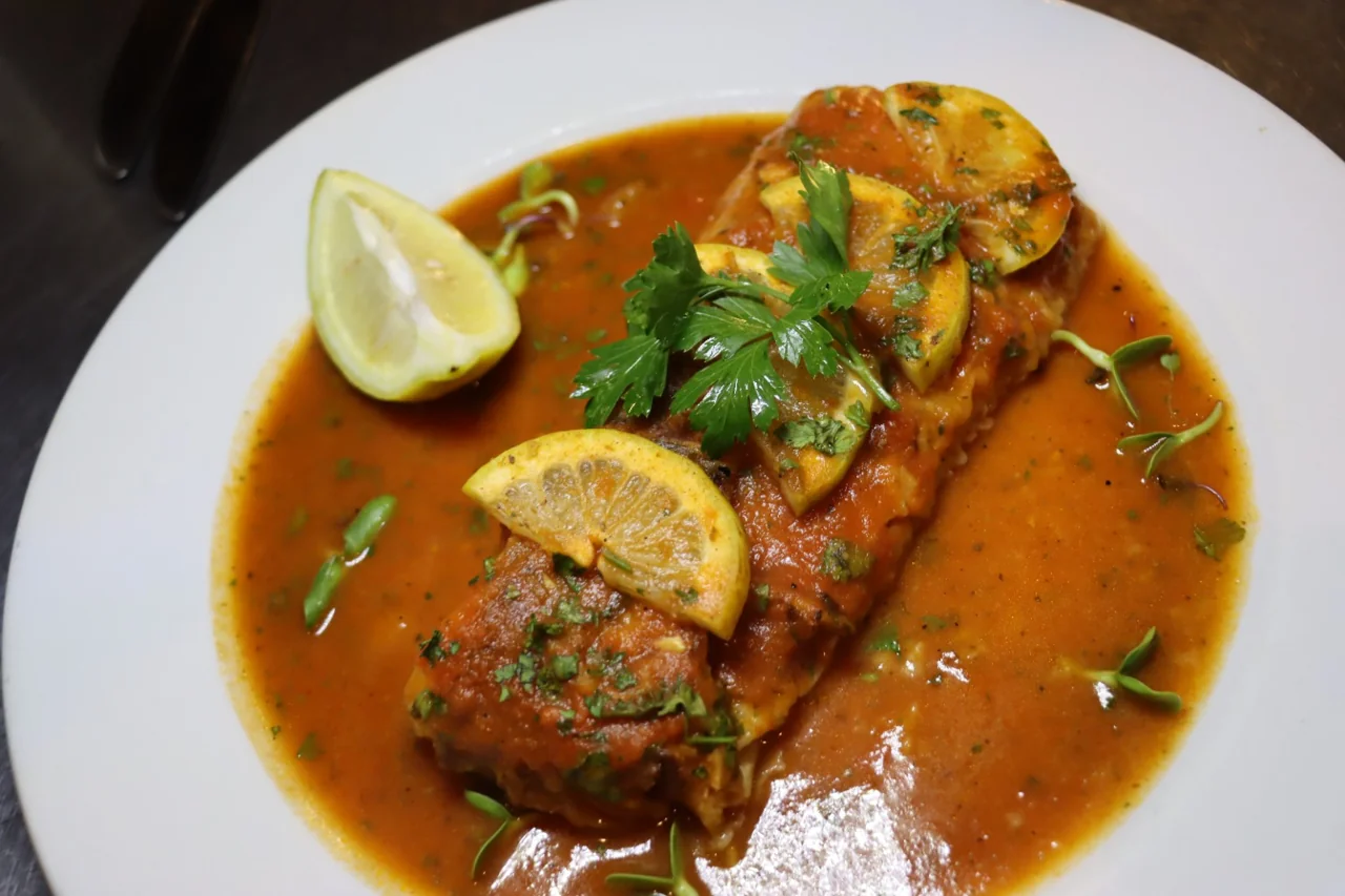 Pescada in tomato and onion sauce with lemon and parsley