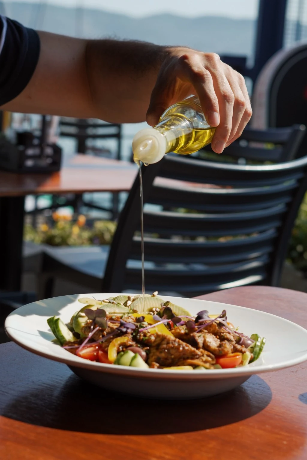 Olive oil being poured over a fresh salad at O Pescador