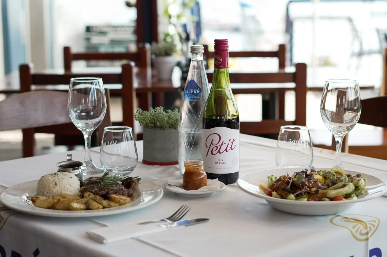 A table set for two with food and wine inside O Pescador