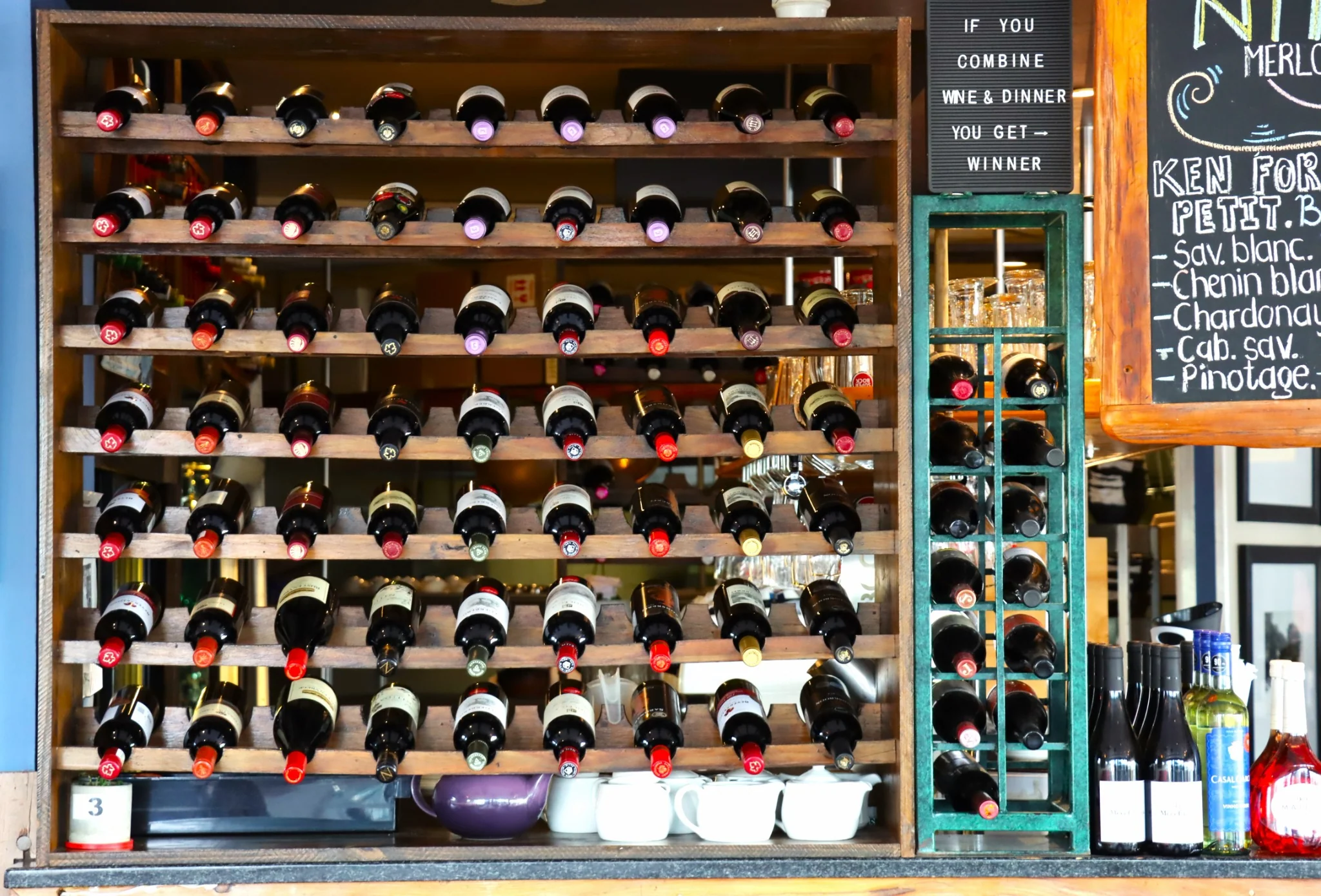 Wooden wine racks and a handwritten wine board inside O Pescador